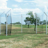 A group of vertical metal poles positioned in a grassy field, with no other structures nearby.